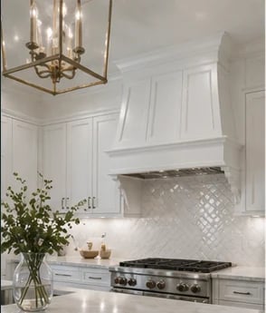 Modern white kitchen with stainless steel gas range, white subway tile backsplash, and brass pendant lighting above counter